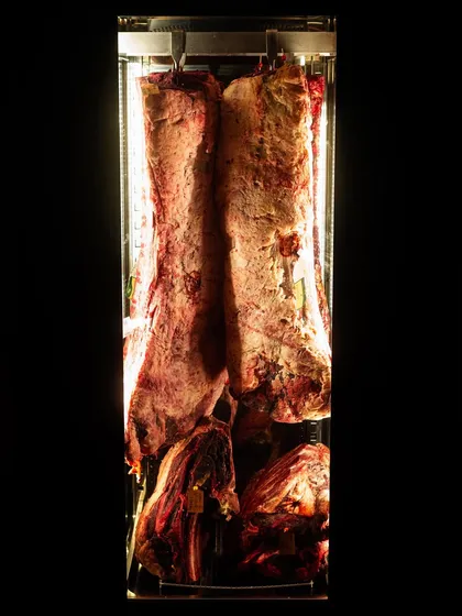 A dramatic shot of dry-aged beef in a display fridge at Temper restaurant. This image tells a story about quality and the restaurant's nose-to-tail philosophy.