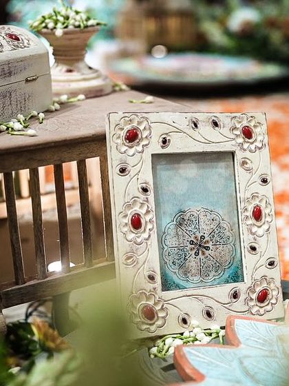 Every detail in this South Indian wedding was a nod to royalty. This close-up shows a hand-carved photo frame and a vintage-style chest, accented with fresh mogra, embodying the regal and timeless theme.