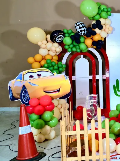 A cutout of Cruz Ramirez from Cars 3, surrounded by balloons and a traffic cone, adding another favorite character to the party scene.