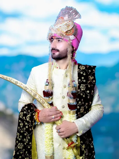 A three-quarter portrait of the groom, looking off to the side. The mountain background adds a sense of grandeur.