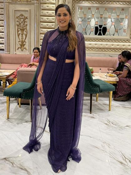 A full-length view of my happy client in the purple cape drape saree. It’s a chic and hassle-free outfit that looks incredible in photos.