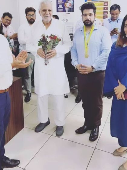 A moment of respect and celebration with colleagues and seniors in the office. A supportive professional environment is crucial.