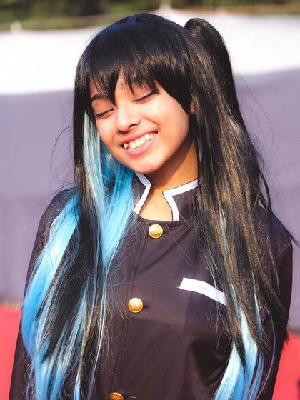 A joyful, candid shot of a cosplayer portraying Muichiro from Demon Slayer. We love capturing these in-between moments that show the fun and passion behind the cosplay.