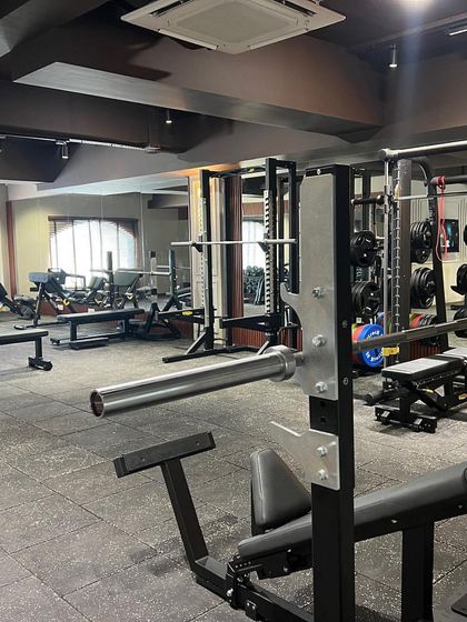 A wide view of our strength training floor, showcasing the variety of machines and free weights available for a complete workout.