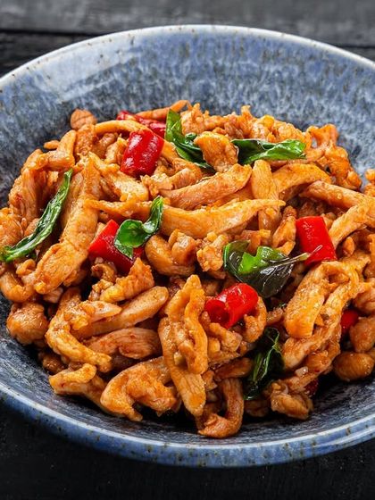 A dry chili chicken stir-fry, focusing on the texture of the chicken and peppers, from the YouMee archives.