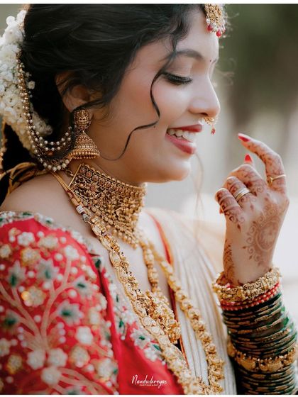 A close-up capturing the bride's infectious smile and the fine details of her jewelry. This candid moment is full of life and happiness.