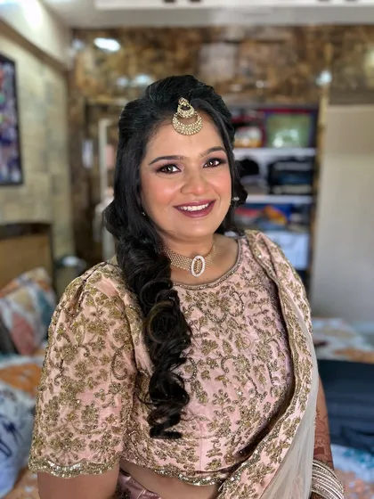 A smiling portrait showing her complete look. The soft curls and glowing makeup make her look radiant.