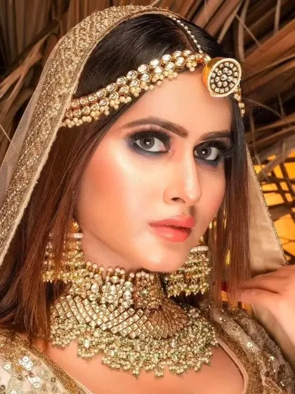 A stunning golden bridal look. The model wears a heavy, champagne-gold colored jewellery set that perfectly matches her sequined lehenga and dupatta.
