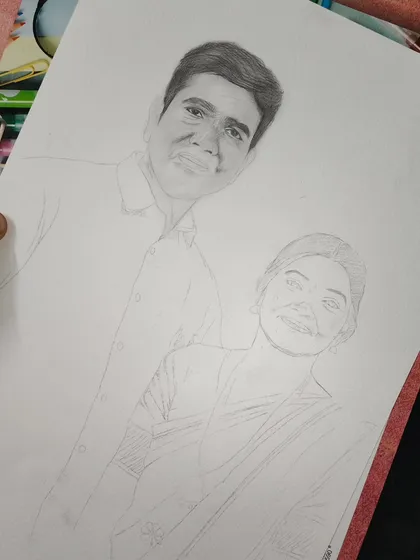 This image captures an early stage of a couple's portrait. The man's face is shaded and detailed, while the woman's portrait is still a line drawing, showing how I build the composition.