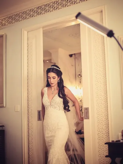 A bride in her white gown, captured as she walks through a doorway.