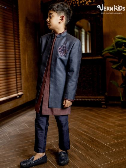 Every detail tells a story of elegance. This layered Indo-western outfit from our Jashn Collection features a deep blue jacket with a subtle, hand-embroidered motif over a contrasting kurta.