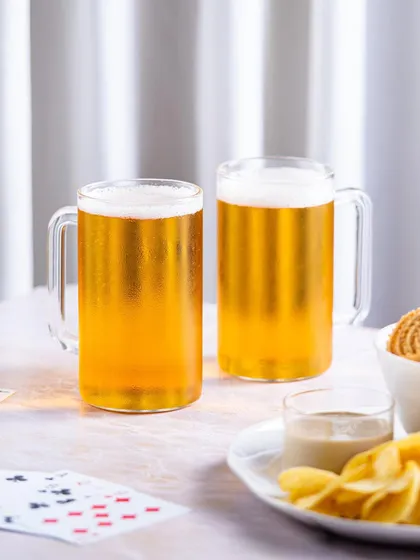 A clean and bright version of the game night setup, with a white background that makes the golden color of the beer stand out.