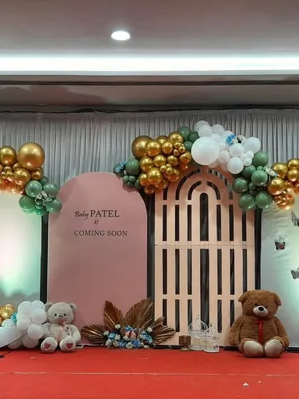 A whimsical baby shower theme with a crescent moon, teddy bears, and a garden gate prop. The sage green, gold, and white color scheme is both elegant and playful.