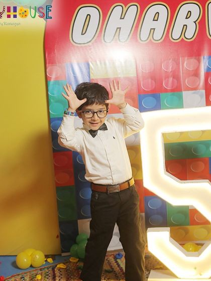 The birthday boy strikes a fun pose, celebrating turning five in style at his awesome LEGO party.