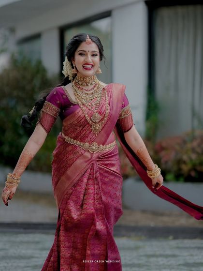 A joyful, full-length portrait of the bride, her happiness evident in her wide smile and open arms.
