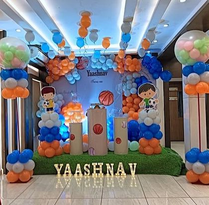 An angled shot of the sports-themed party, highlighting the balloon pillars and stage setup.