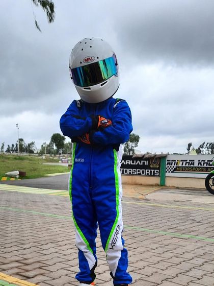 A young driver in his full race suit.