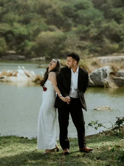 A moment of shared laughter by the water's edge, showcasing a relaxed and natural couple portrait. I believe the best photos happen when you forget the camera is even there, letting your true connection shine.
