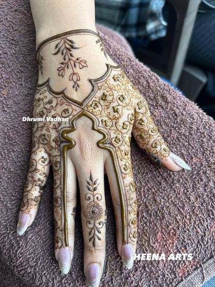 An elegant Arabic-style design on the back of the hand, with a focus on flowing vines and leaves.