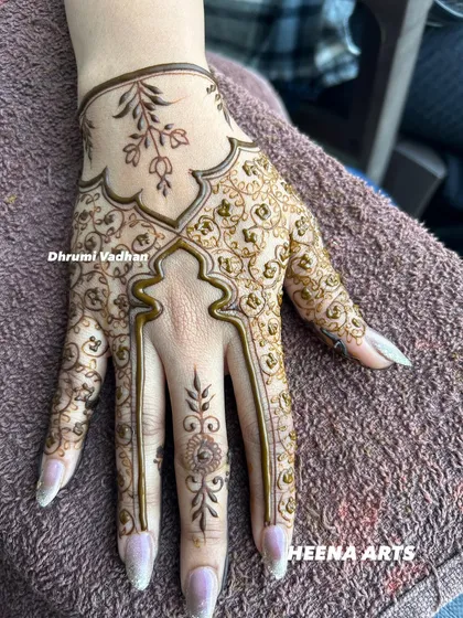 An elegant Arabic-style design on the back of the hand, with a focus on flowing vines and leaves.