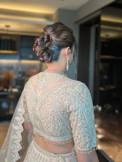 A beautiful and intricate messy bun, perfect for a reception or cocktail party.