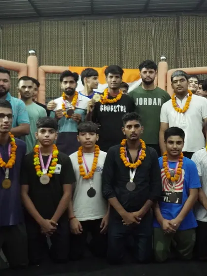 The full team poses with our kickboxing medalists, sharing in the pride of their accomplishments.