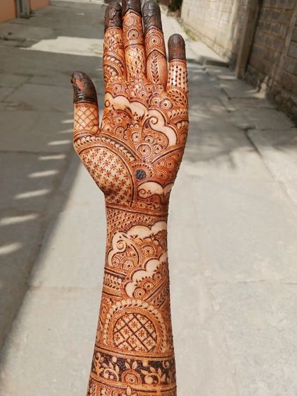This is a full bridal mehendi I practiced on myself, inspired by one of my favorite artists. It features cloud-like swirls, intricate netting, and varied finger designs, covering the hand and arm completely.