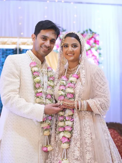 A beautiful formal portrait of the smiling couple in their elegant pastel wedding outfits.
