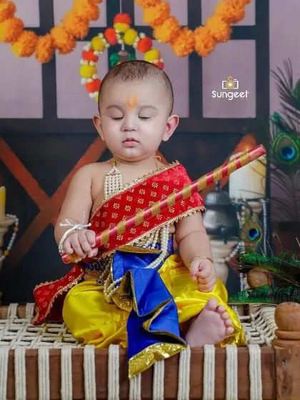 A contemplative moment for our Little Krishna. The details in this setup, from the peacock feathers to the marigold garlands, create an authentic and beautiful scene.