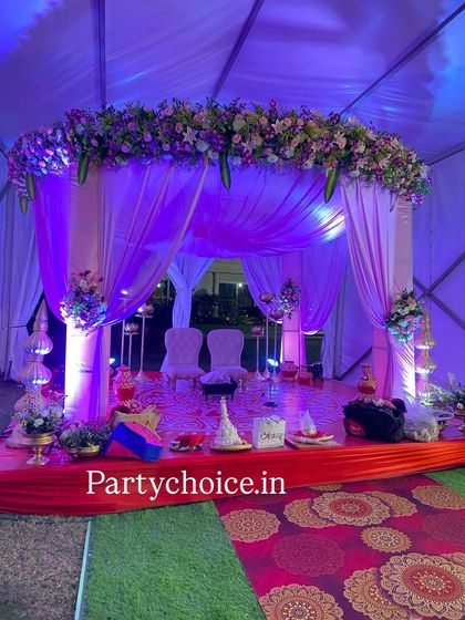 This mandap was designed for a Bengali wedding ceremony. We used purple and white drapes, a dense floral arrangement on top, and traditional elements on the stage to create an intimate and culturally specific setting inside a tent.