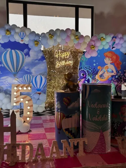 A creative twin-themed birthday combining Hot Air Balloons for the boy and Mermaids for the girl into one cohesive decoration.