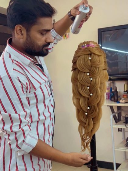 An instructor demonstrates the final spray and setting techniques for an intricate braid, teaching students how to ensure longevity.