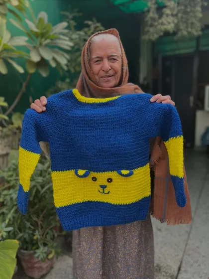 Simple, cute, and cozy. This blue and yellow striped sweater has a subtle bear face outline, making it a playful yet versatile piece for everyday wear.