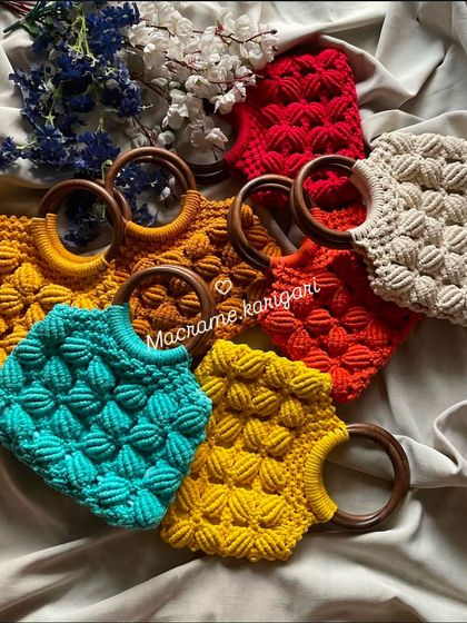 A colorful array of our crochet bags with wooden ring handles. This design features a textured puff stitch and comes in many vibrant colors, making it a stylish and modern accessory.