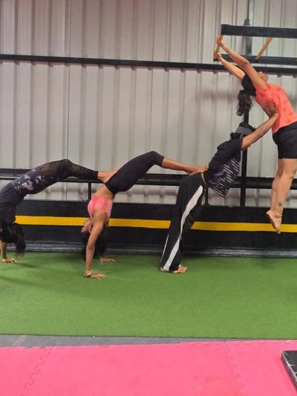 Time to pose in a different way. Our adult students having fun with an acro yoga pose, showcasing their strength and teamwork.