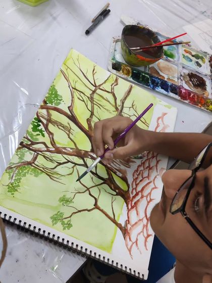 A teen student learns to draw and paint a complex tree structure, focusing on the fundamentals of form and color.