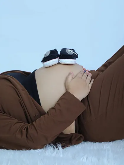 Sometimes the smallest details tell the biggest story. This creative shot with tiny baby shoes on the baby bump is a sweet and simple way to announce your little one is on the way.