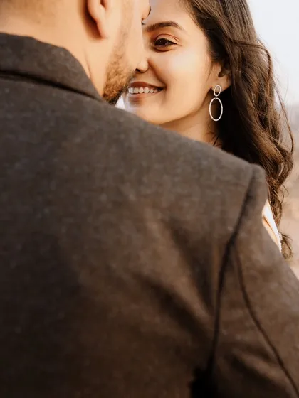 A lovely over-the-shoulder shot capturing the bride's beautiful smile as she looks at her partner. It's a perfect example of a natural, in-between moment.