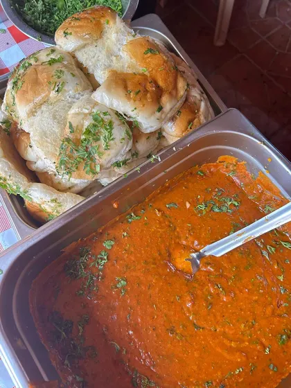 A close-up of the rich pav bhaji and soft, buttered pav served at a Holi party. This Mumbai street food classic is the perfect fuel for a day of colorful celebrations.