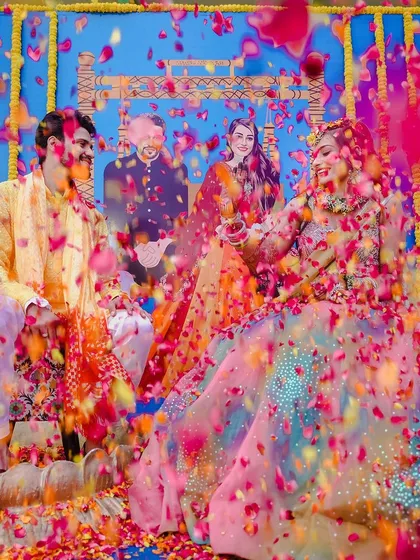 The pure, unadulterated joy of a Haldi ceremony. This shot, with a shower of vibrant flower petals, captures the energy and color that make Indian pre-wedding rituals so special and memorable.