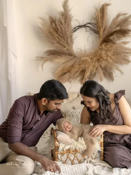 Welcoming a new life is a moment of profound tenderness. I love creating a calm space for new parents to simply adore their baby, and I document that quiet love. This is a classic newborn and parents portrait from my HSR Layout studio.