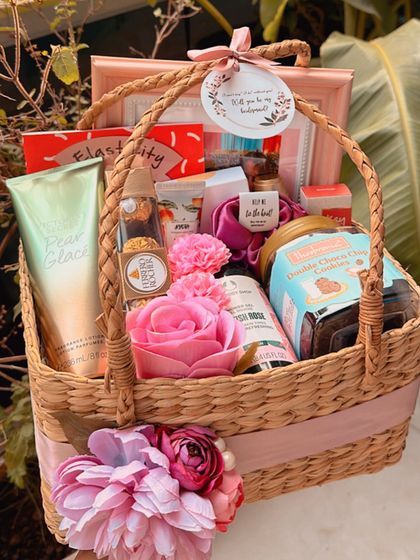 This bridesmaid proposal basket is overflowing with treats! It includes a photo frame for a cherished memory, skincare from The Body Shop and Victoria's Secret, cookies from Theobroma, and other pampering essentials.