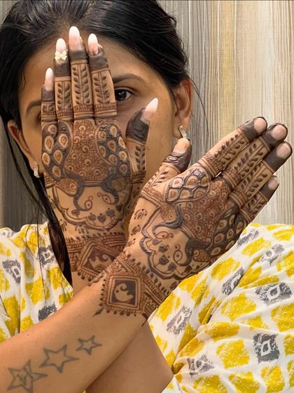 A client showing off her peacock-themed mehendi. The design is intricate but doesn't cover the entire arm, making it ideal for various occasions.