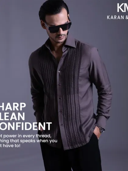 A graphic overlay on the grey pintuck shirt, emphasizing its quiet power and enduring style.