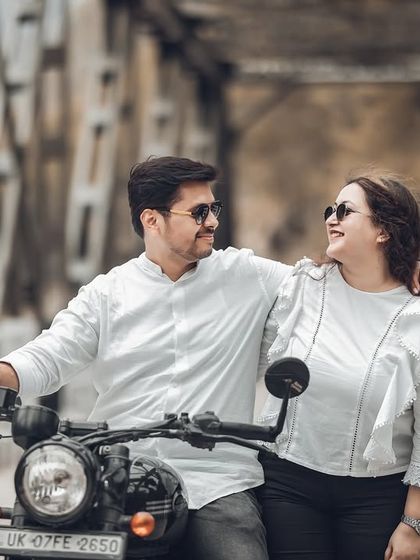 A close-up shot of the couple on the motorcycle, sharing a happy and genuine smile. This highlights their joy and the fun they're having during their engagement photoshoot.