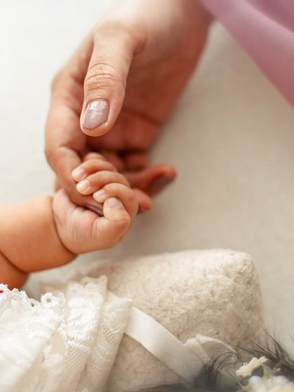 A newborn's tiny hand grasping her mother's finger. This simple, powerful image symbolizes trust and the unbreakable bond between them.