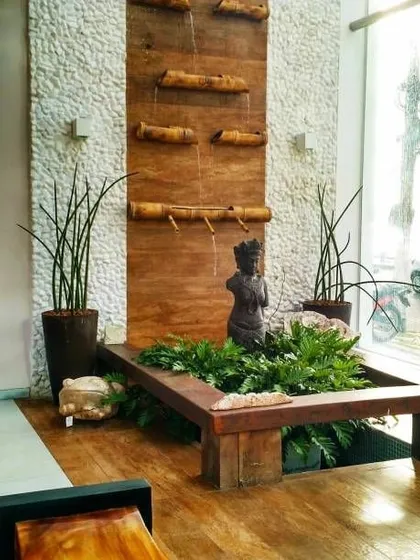 Adding a water feature is a wonderful way to bring tranquility indoors. I designed this custom piece that combines a gentle bamboo waterfall with a bed of low-light plants, creating a focal point that is both visually beautiful and calming to the senses.