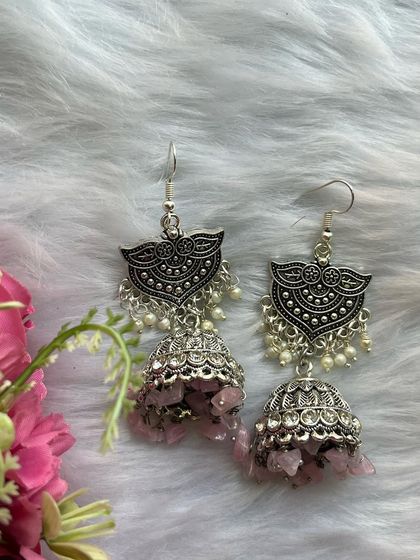 A clear shot of the uncut pink bead jhumkas, showing the delicate pearl loreals and detailed silver work.