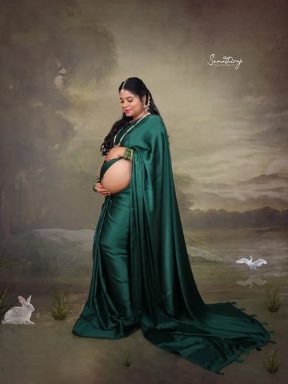 Draped in a stunning emerald green satin saree, this mother-to-be traveled from Tamil Nadu for her shoot. Her portrait is a blend of modern elegance and traditional grace, set against a dreamy, artistic backdrop.