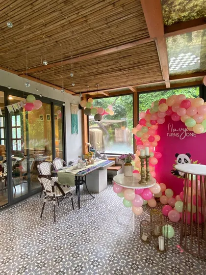 A wider shot of the panda-themed party in a beautiful venue with large windows.